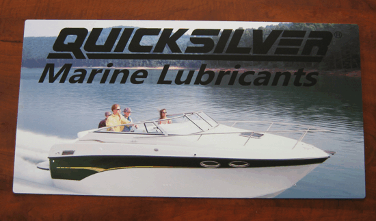 Quicksilver Marine Lubricants ad with a white speedboat on calm water at sunset