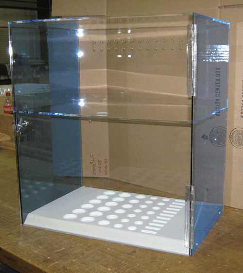 Empty glass display case with blue-tinted sides on a wooden table in a store-like setting
