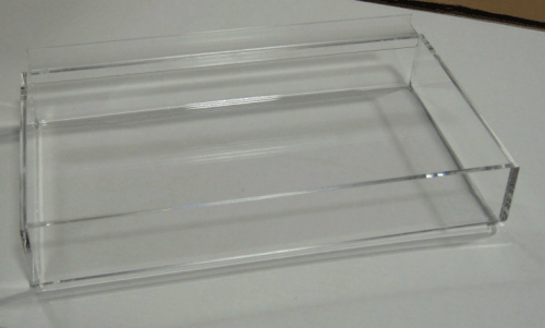 Clear plastic tray with raised sides on a white surface