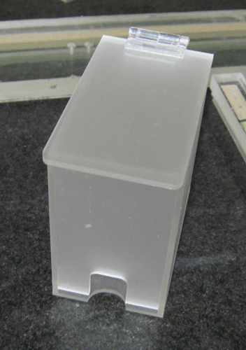 Translucent plastic box with a hinged lid and a small front notch, sitting on a surface