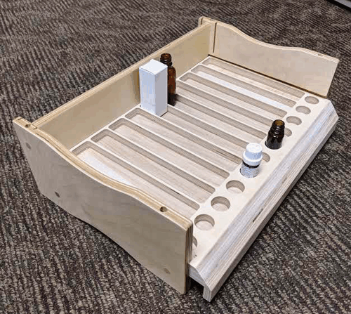 Wooden marble-run board with white tracks and small blocks on a carpeted floor