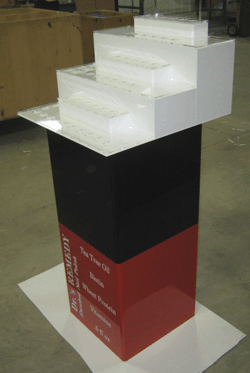 White stepped display model on a black-and-red pedestal in an indoor setting