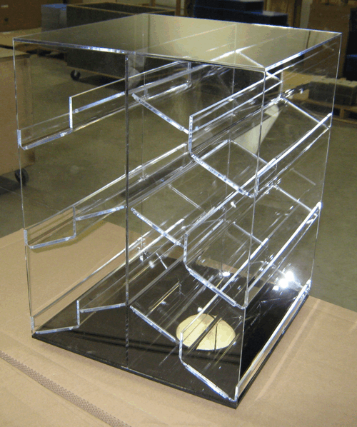 Clear acrylic display case with angled shelves and a black base on a table