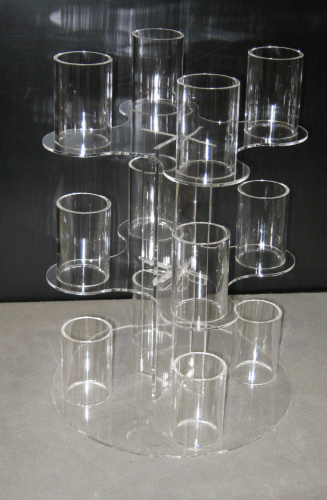 Stacked clear plastic cups arranged in a display on a dark shelf