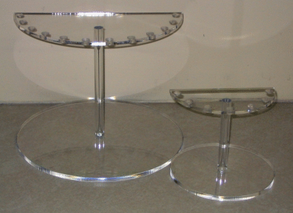 Two clear glass tiered serving stands on a light surface.