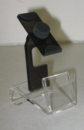 Clear acrylic phone stand with black adjustable clip on a plain background