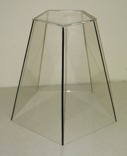 Clear hexagonal glass table pedestal frame on a light background