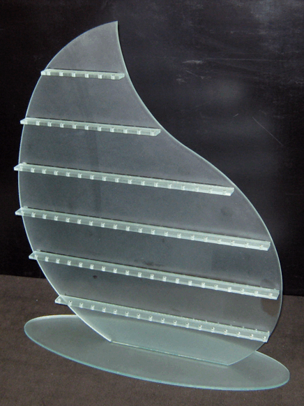 Clear glass abstract sculpture with curved horizontal slats on an oval base against a dark background