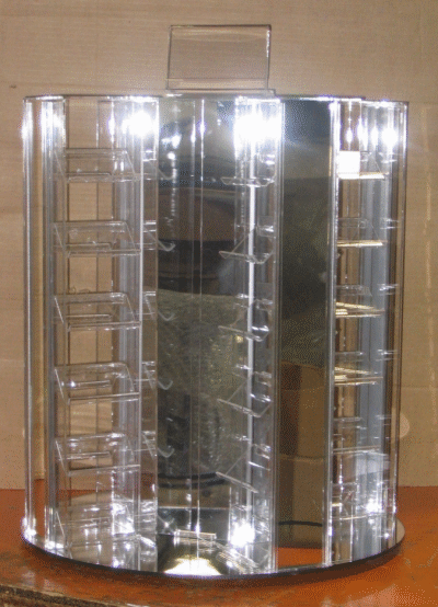 Transparent acrylic display case with curved front and metal shelving, standing on a table