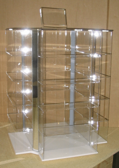 Clear acrylic rotating display case with multiple shelves on a white base