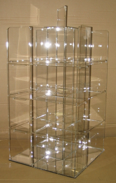 Transparent acrylic rotating display stand with multiple shelves on a reflective floor