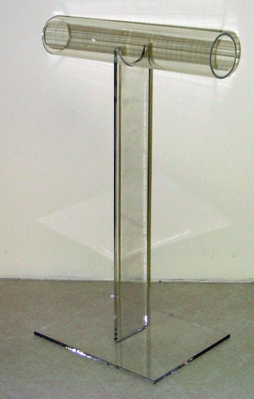 Clear acrylic lectern with a T-shaped top and square base on a plain floor
