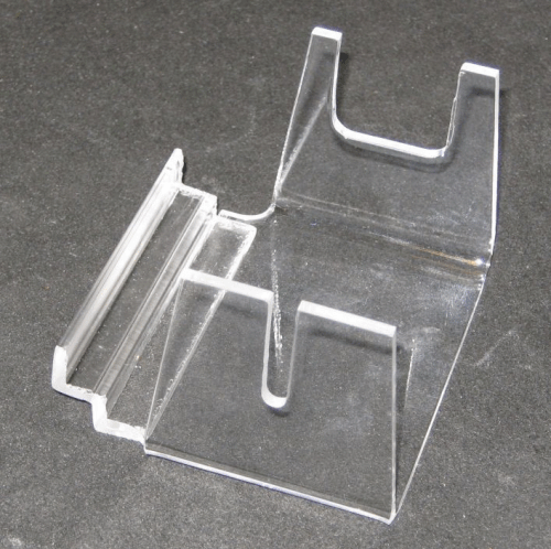 Clear plastic phone stand with slots, shown on a gray surface