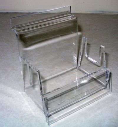 Clear acrylic brochure holder with multiple compartments on a gray surface
