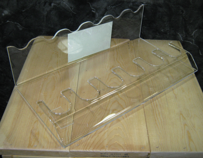 Clear plastic document holder with multiple slots on a wooden surface against a dark background