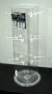 Transparent acrylic display case with shelves on a round black base, shown against a black background
