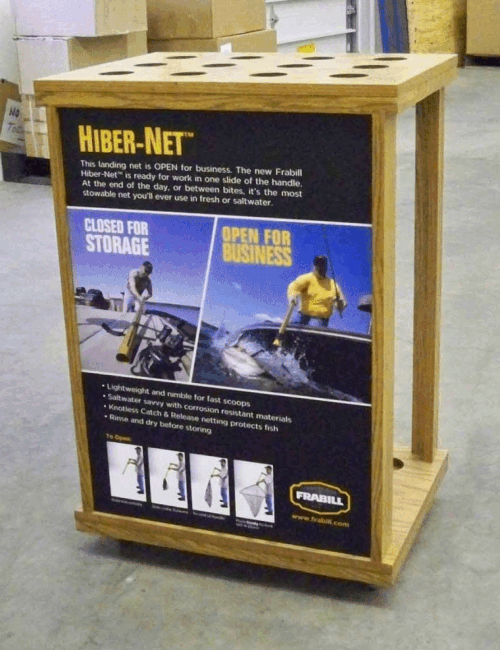 Wooden display stand with a Hiber-Net poster showing two motorcyclists in blue and yellow action scenes.