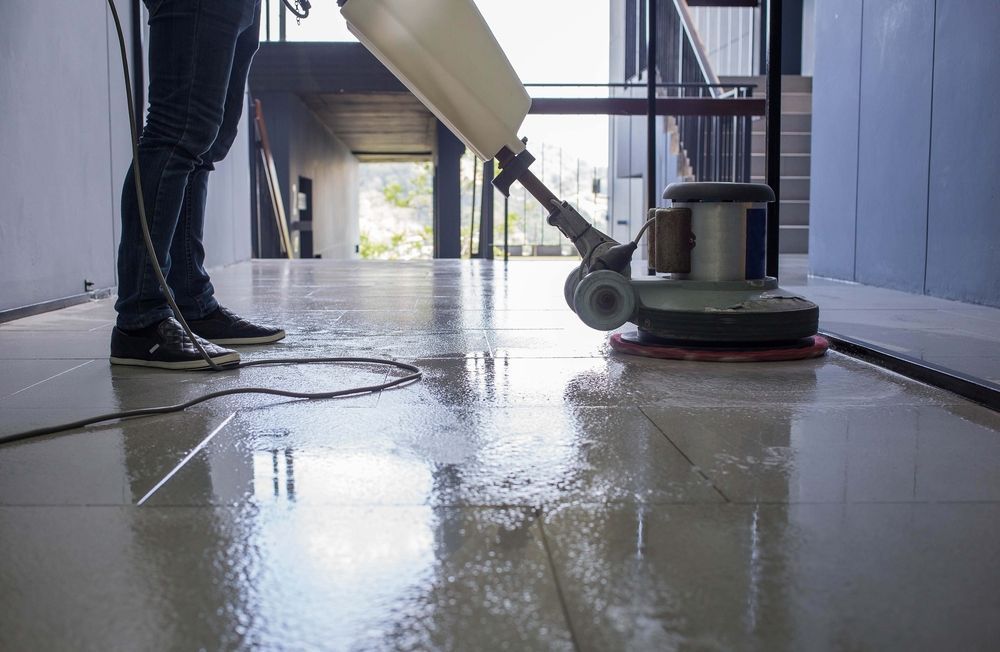 Person Using a Floor Polisher to Clean a Shiny Tile Floor Indoors — Crystal Clear In Walcha, NSW