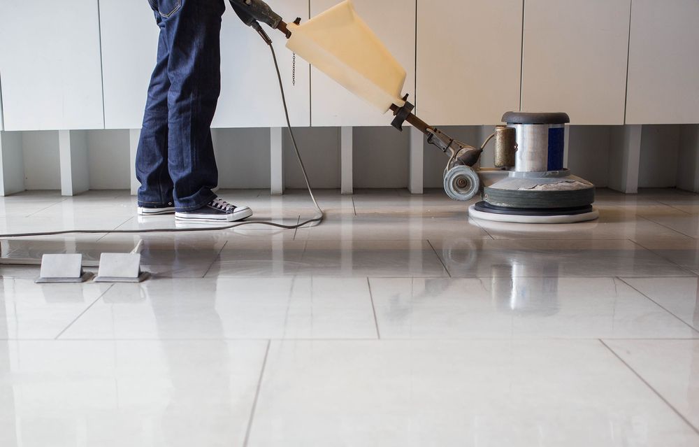 Person Polishing a Shiny, White Tiled Floor With an Industrial Floor Buffer Machine — Crystal Clear In Glen Innes, NSW