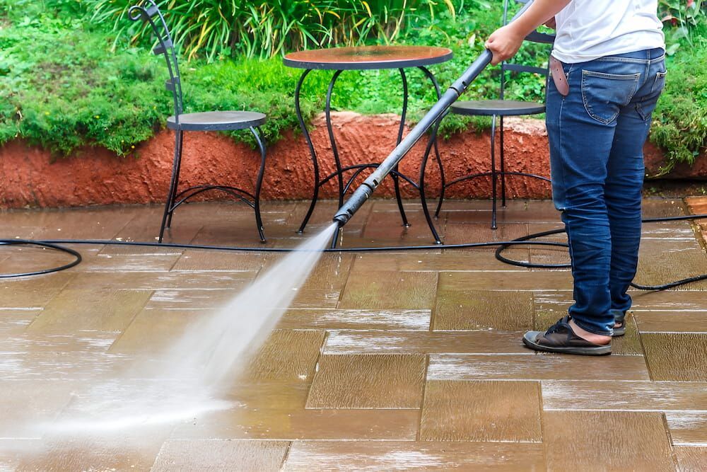 Person Power Washing a Patio With a High-pressure Washer — Crystal Clear In Walcha, NSW