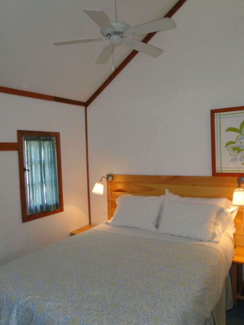 A bedroom with a bed and a ceiling fan