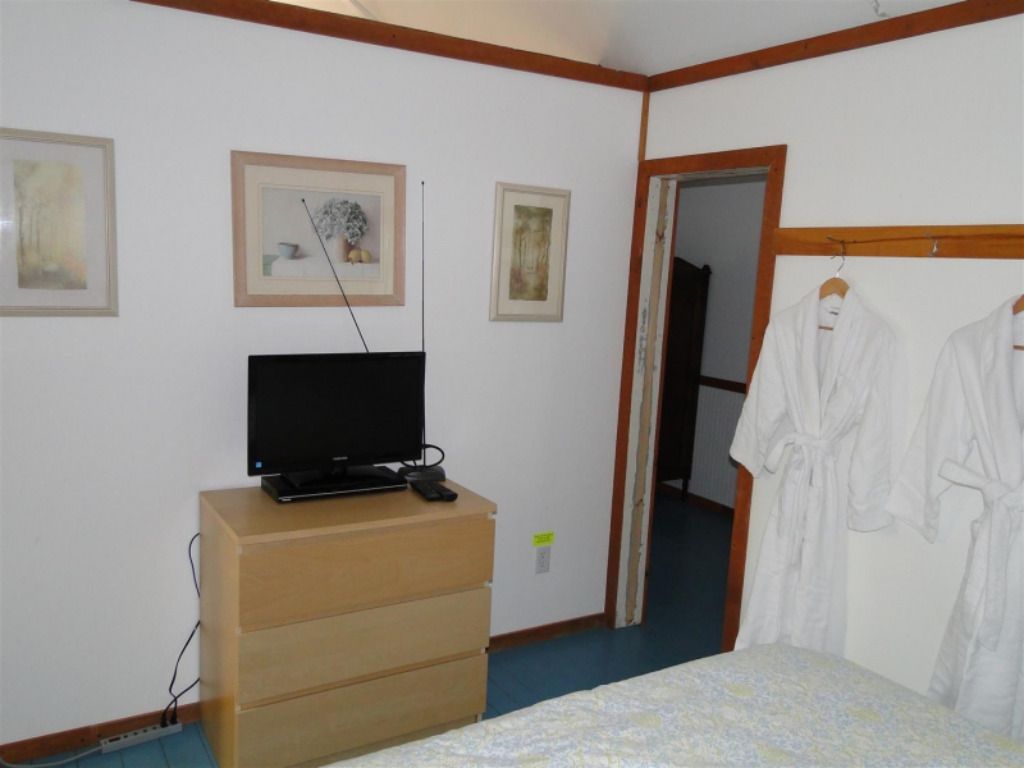 A bedroom with a dresser and a flat screen tv