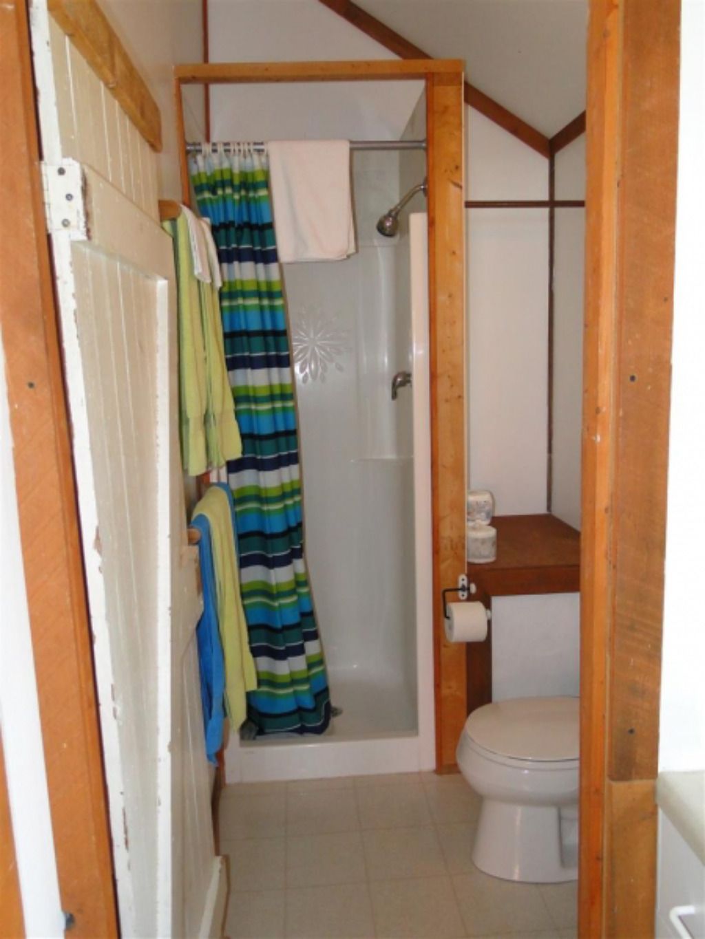 A bathroom with a striped shower curtain and a toilet