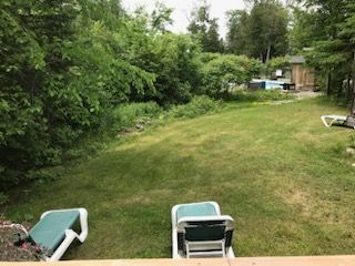 A couple of chairs sitting on top of a lush green lawn.
