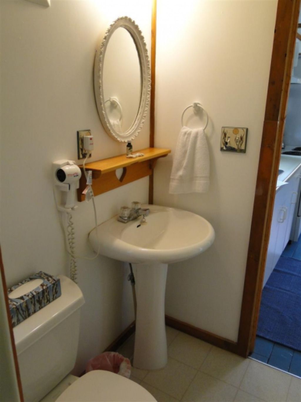 A bathroom with a toilet a sink and a mirror