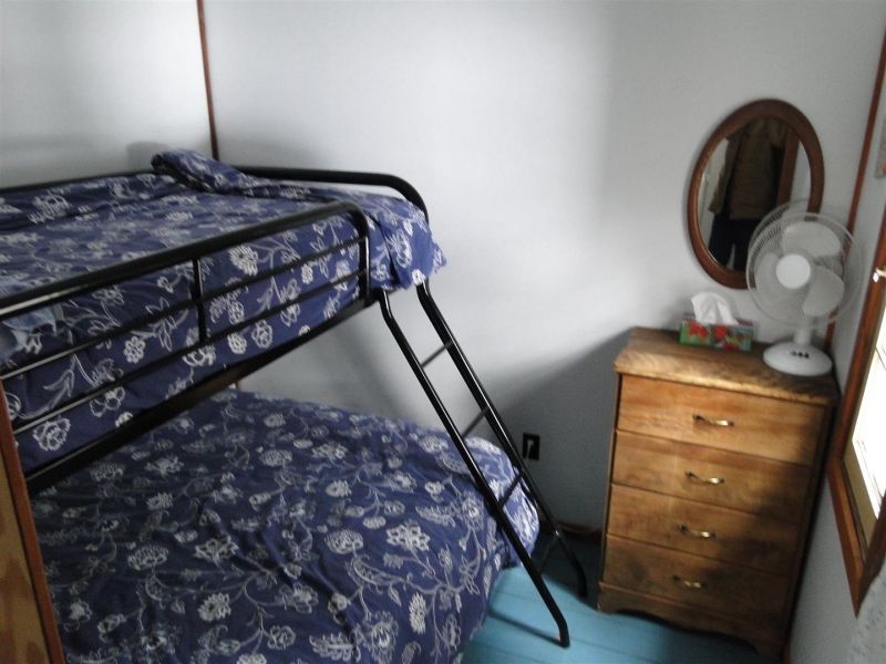 A bedroom with two bunk beds and a dresser