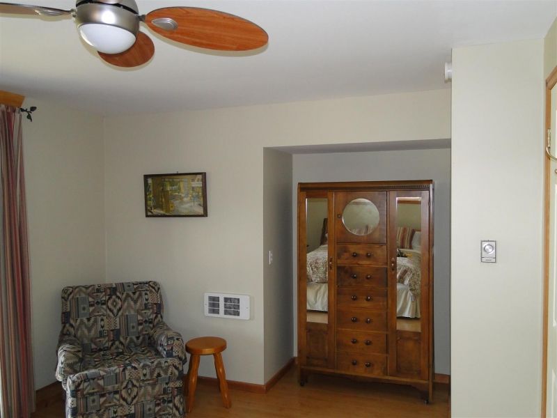 A living room with a chair and a ceiling fan