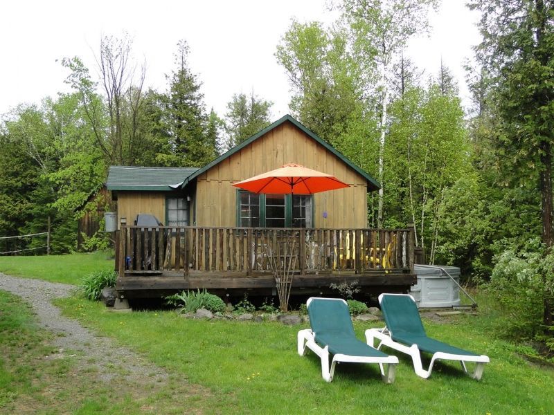 A small house with a large deck and umbrella