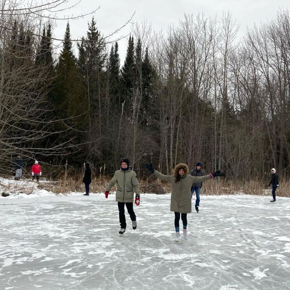 A group of people are ice skating on a frozen lake.
