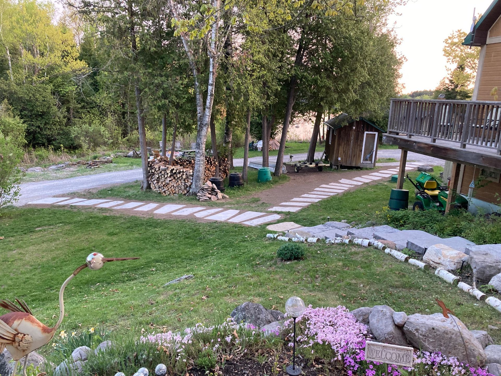 A lush green yard with a stone walkway leading to a house.