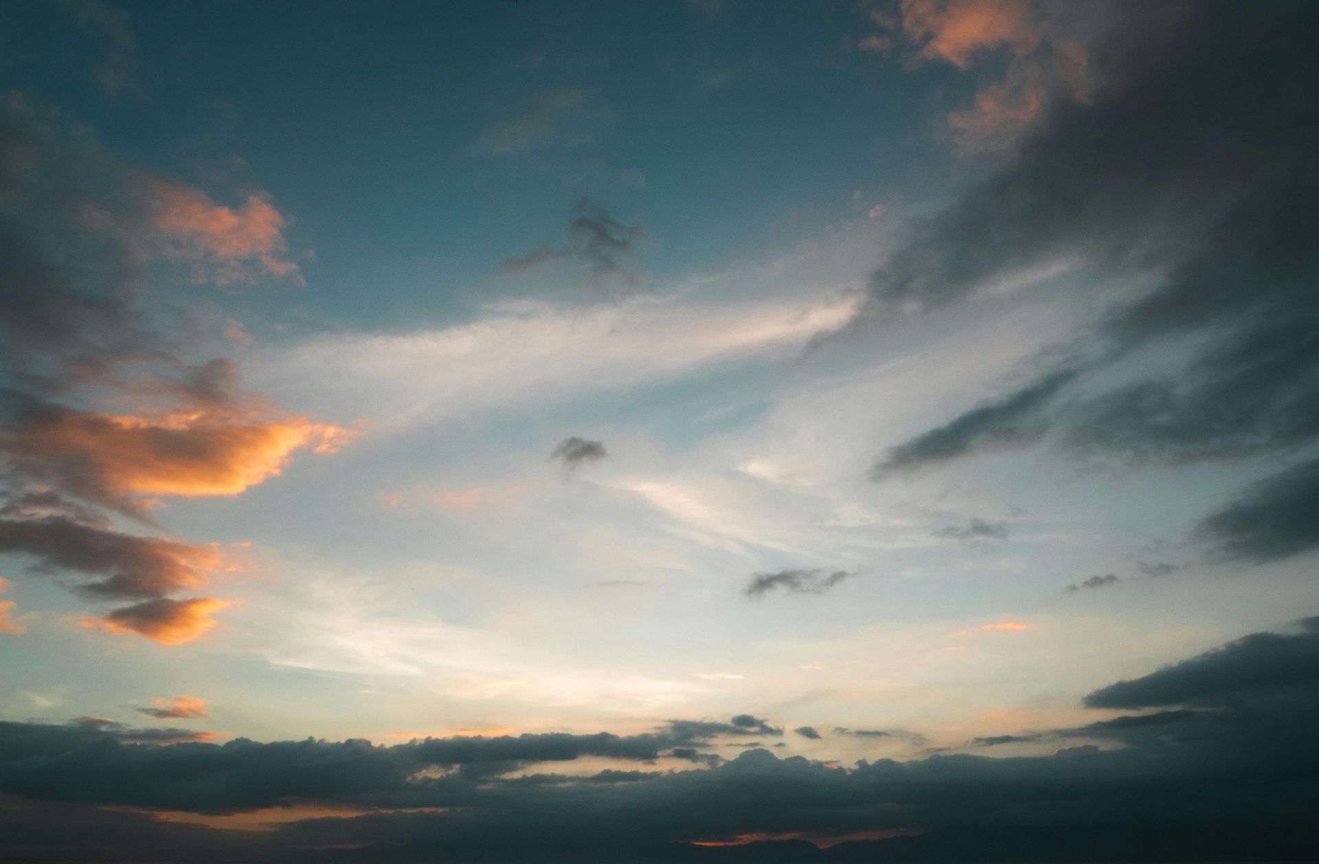 Sunset sky with blue, gray, and orange clouds.