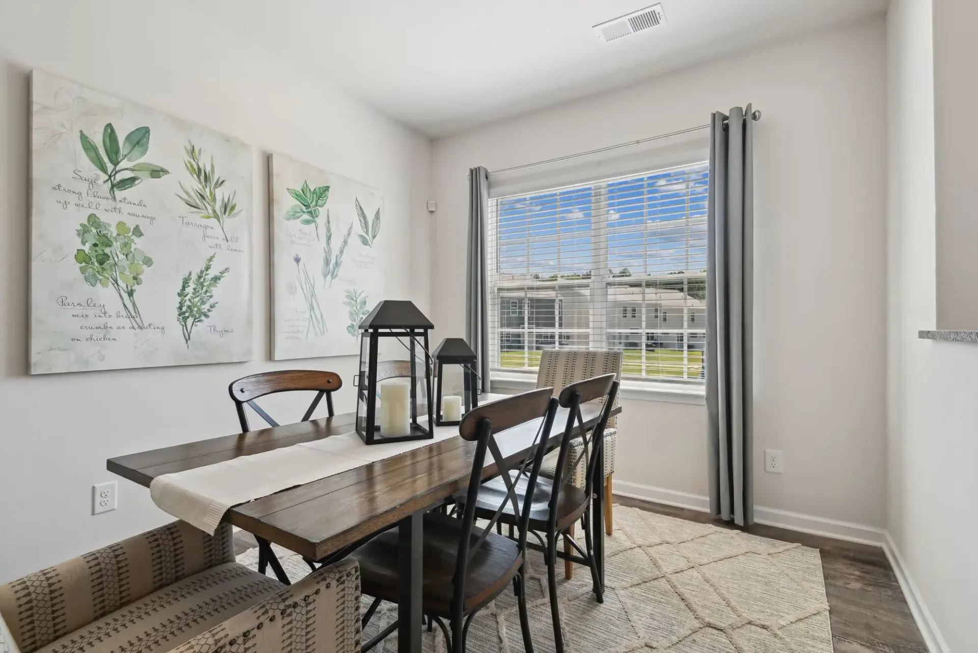 Dining area with a wooden table, metal chairs, and a large window with white blinds.