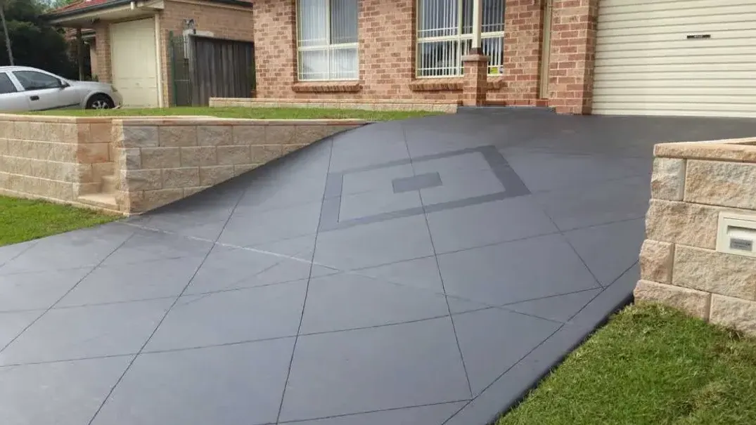 Dark grey colored concrete driveway with cuts