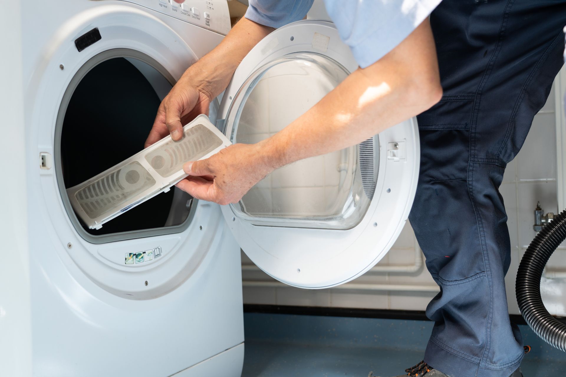 A person is taking a filter out of a dryer