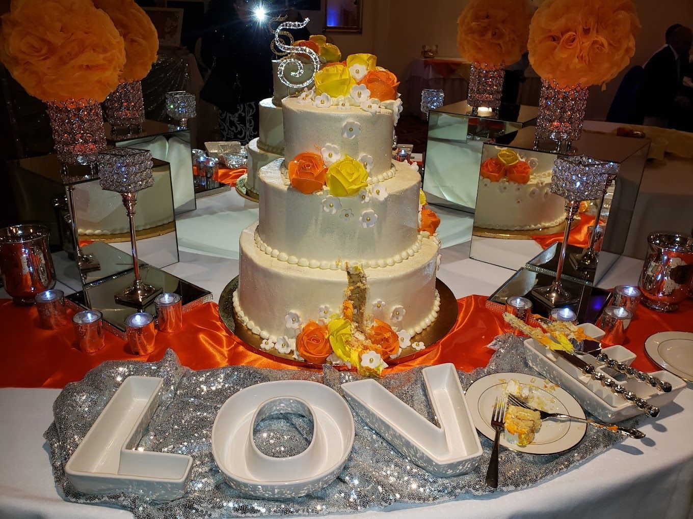 A wedding cake on a table with a sign that says love