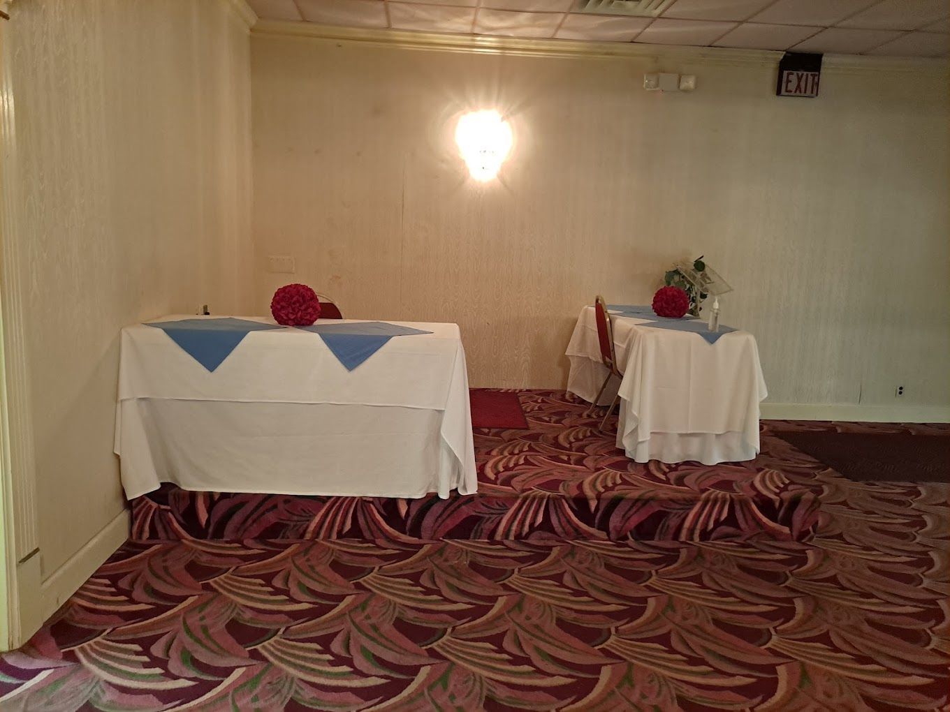 A room with two tables and a carpet on the floor