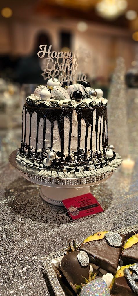 A birthday cake is sitting on top of a cake stand on a table