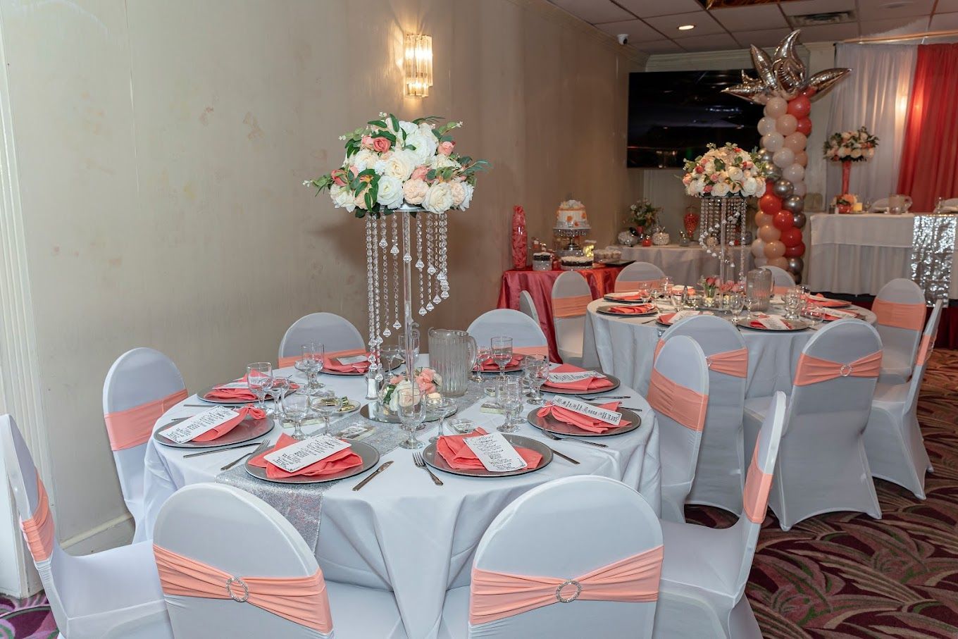 A room with tables and chairs set up for a wedding reception