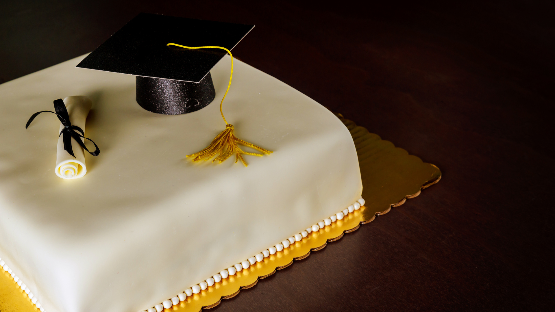 A graduation cake with a graduation cap and diploma on top