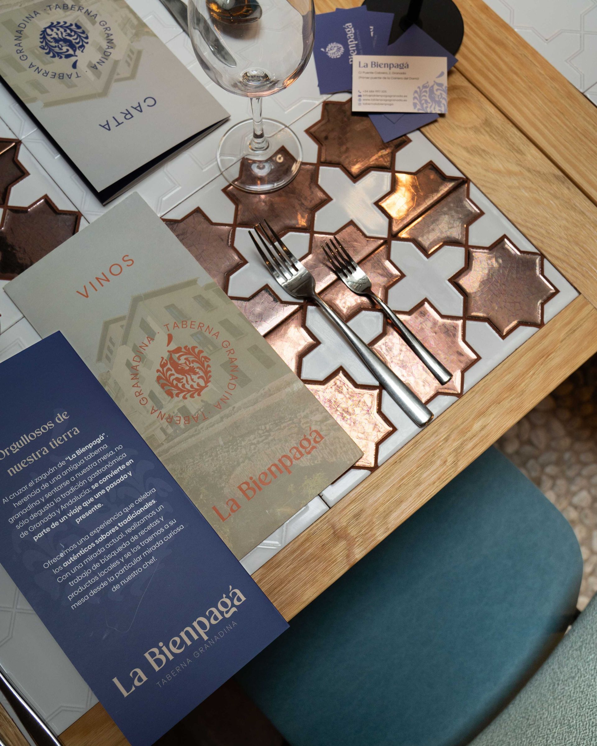 Mesa con envases de comida variados y adornos de estrellas de color cobre sobre una silla azul cercana.