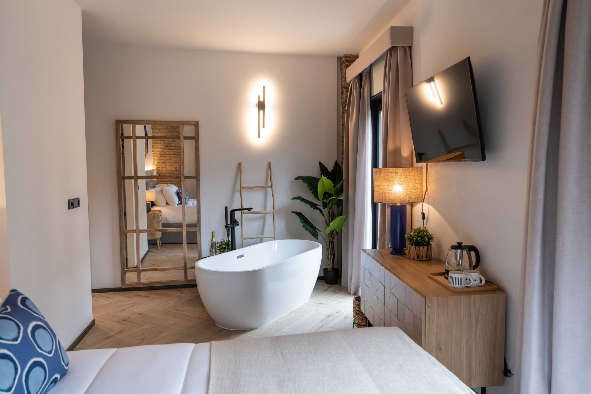 Baño moderno con toallero, inodoro y zona de ducha de cristal con grifería negra.