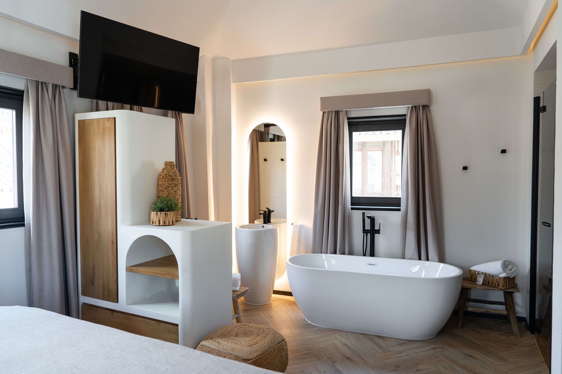 Baño moderno con bañera independiente, lavabo elegante y detalles contemporáneos en tonos neutros.