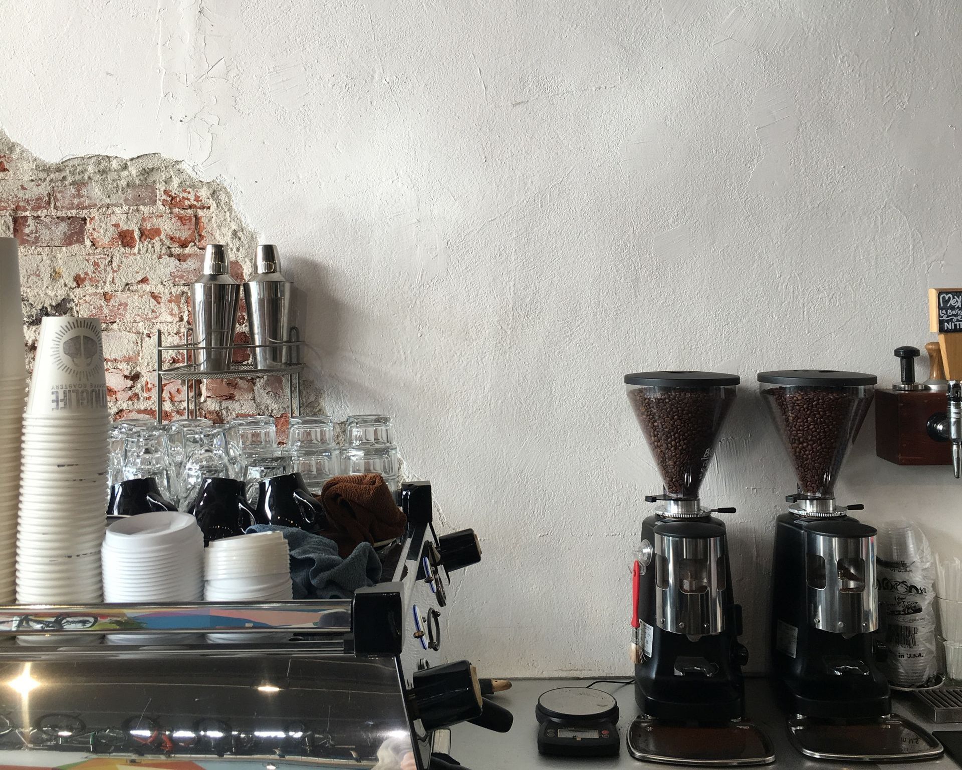Dos molinillos de café están sobre un mostrador en una cafetería.