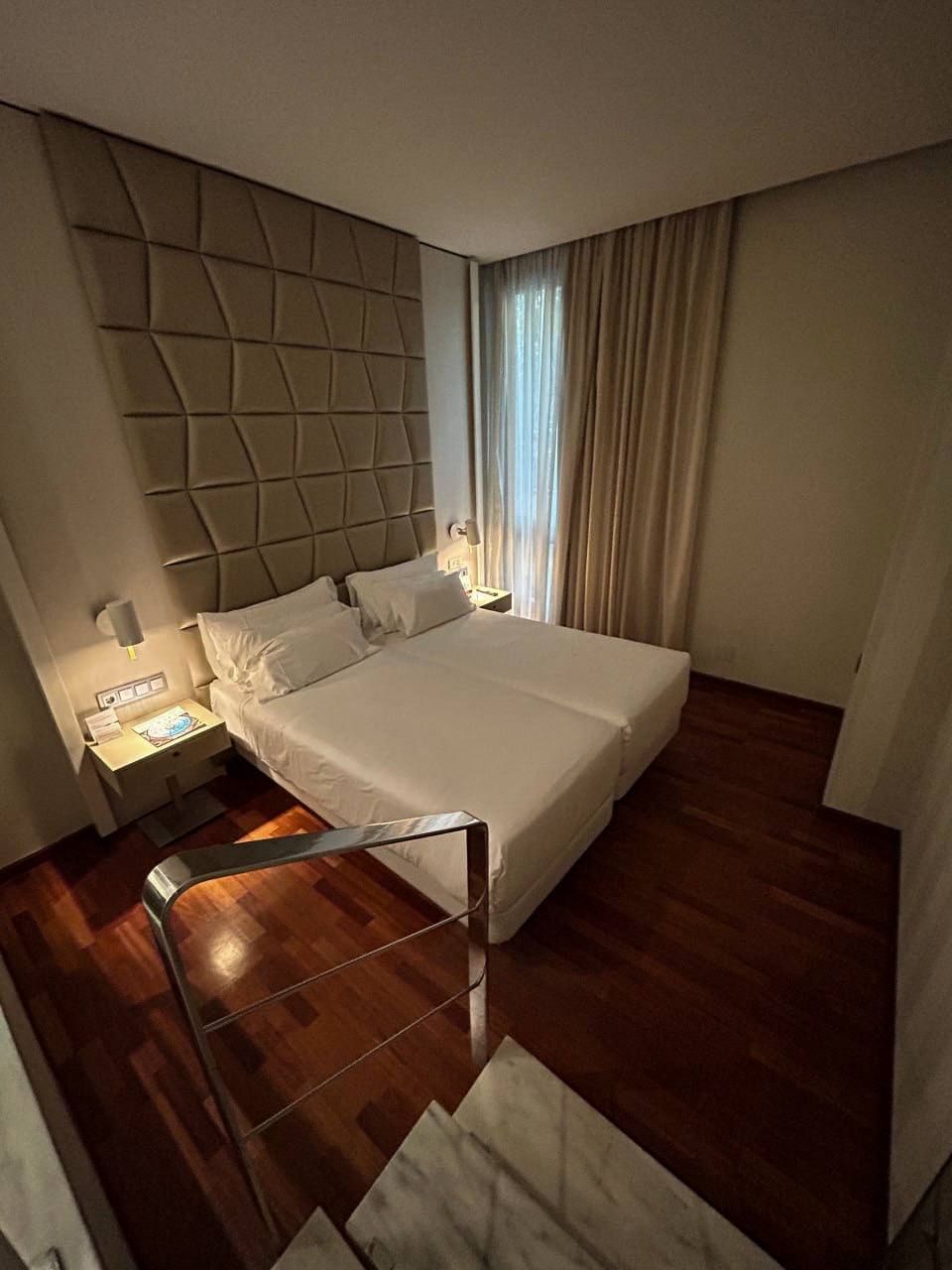 Una habitación de hotel con una cama grande y escaleras que conducen a ella.