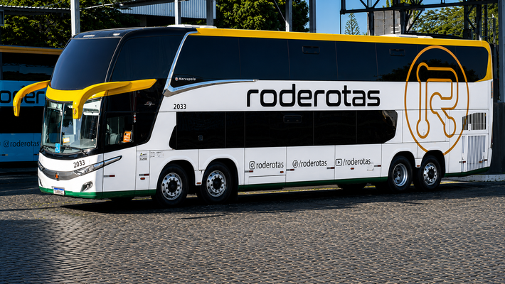 Um ônibus de dois andares com roderotas.com escrito na lateral está estacionado na beira da estrada.