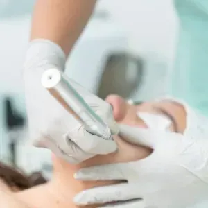 Dental cleaning in progress, with gloved hands using a tool on a patient’s mouth.